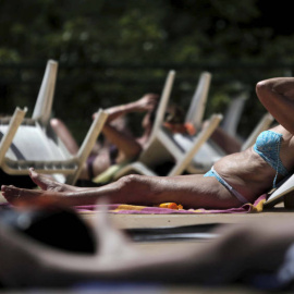 Varios bañistas toman el sol en la piscina municipal al aire libre del Canal de Isabel II/ EFE