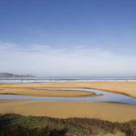 Dos personas pasean por la playa América en el ayuntamiento de Nigrán, Pontevedra.