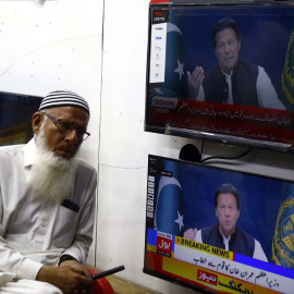 Un hombre junto a unas pantallas de televisión con la imagen del primer ministro paquistaní, Imran Jan, a 9 de abril de 2022.