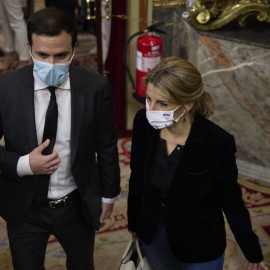 El ministro de Consumo, Alberto Garzón, y la vicepresidenta segunda y ministra de Trabajo y Economía Social, Yolanda Díaz, conversan en un pleno en el Congreso de los Diputados, a 15 de marzo de 2022, en Madrid (España). Los socios parlamen