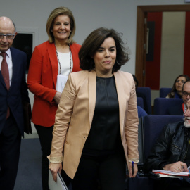 La vicepresidenta del Gobierno, Soraya Saenz de Santamaría, acompañada por los ministros de Hacienda y de Empleo, Cristóbal Montoro y Fátima Báñez, respectivamente, a su llegada a la rueda de prensa posterior a la reunión del Consejo de Min