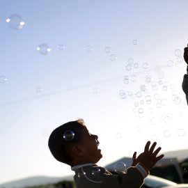 Niños juegan con burbujas de jabón en un campamento improvisado para refugiados en la frontera entre Grecia y Macedonia, cerca de la localidad de Idomeni. REUTERS/Stoyan Nenov