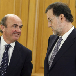 El ministro de Economía, Luis de Guindos, y el presidente del Gobierno, Mariano Rajoy, en una foto de junio de 2011 en el Palacio de la Zarzuela, en la jura del cargo del gobernador del Banco de España Luis Maria Linde.AFP