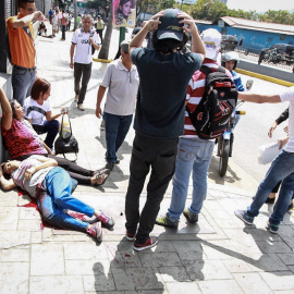 os mujeres yacen en el suelo durante un enfrentamiento entre un grupo de personas adeptas al oficialismo y personas opositoras al gobierno nacional durante la consulta popular hoy, domingo 16 de julio de 2017, en el oeste de Caracas (Venezu