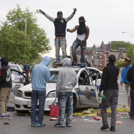 Varios jóvenes se suben a un coche de la policía en medio de las protestas por la muerte de Freddie Grey en Baltimore. EFE