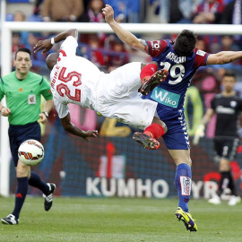 El delantero italiano del Eibar Federico Piovaccari (d) disputa un balón con el centrocampista camerunés del Sevilla Stéphane M'Bia (i). /EFE