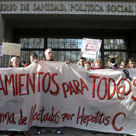 Varias personas participan en una cadena humana, organizada por la Plataforma de Afectados por la Hepatitis C, rodeando el Ministerio de Sanidad para exigir tratamientos para la enfermedad.- EFE/Ballesteros