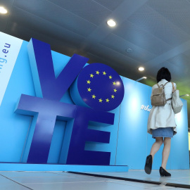 Una mujer pasa frente a un tablero publicitario para las elecciones de la UE en la estación de tren Schuman cerca del Parlamento Europeo en Bruselas. Reuters