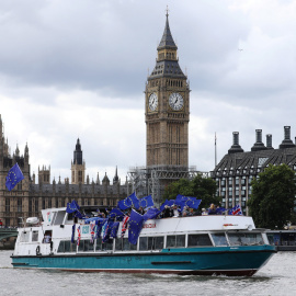 Un grupo de opopsitores al Brexit, con banderas de la UE en una barcaza por el Támesis de Londres, frente al edificio del Parlamento y la torre del 'Big Ben'. REUTERS/Luke MacGregor