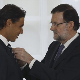 El presidente del Gobierno, Mariano Rajoy, impone al tenista Rafael Nadal, la Medalla de Oro al Mérito en el Trabajo, durante un acto celebrado este viernes en el Palacio de la Moncloa. EFE/Sergio Barrenechea