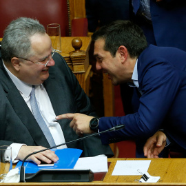 El primer ministro griego, Alexis Tsipras, conversa con el ministro de Exteriores,Nikos Kotzias, durante la moción de censura en el Parlamento griego.-  REUTERS