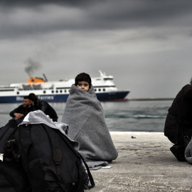 Un niño refugiado cubierto con mantas en el puerto de Mitilene, en Lesbos. ARIS MESSINIS / AFP