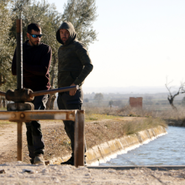 25-4-2023 Dos regadors miren l'aigua del Canal d'Urgell el primer dia de la campanya de reg