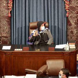 Un seguidor de Trump se sienta en la Cámara del Senado de EEUU durante el asalto.