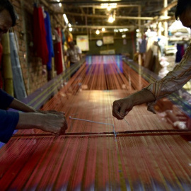 Dos tejedores trabajan en una fábrica de telas en Dacca. - AFP