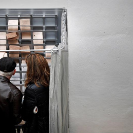 26/05/2019 - Dos personas eligen sus papeletas para votar en un colegio electoral de Pamplona este domingo en una jornada en la que los ciudadanos podrán elegir este 26 de mayo a sus representantes en la Cámara foral, en el Parlamento Europ