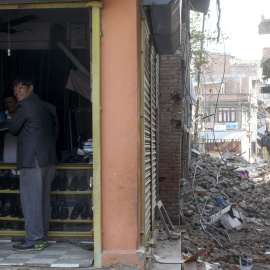 Un hombre compra zapatos en una tienda de la ciudad de Sankhu. /  REUTERS (Athit Perawongmetha)