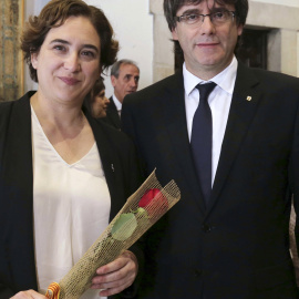 Carles Puigdemont, junto a la alcaldesa de Barcelona, Ada Colau, tras regalarle la tradicional rosa, con motivo de la festividad de Sant Jordi. EFE/Ruben Moreno