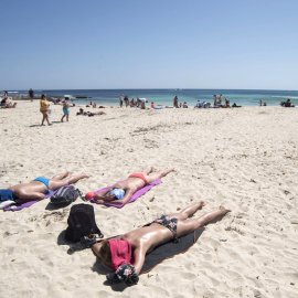 16/04/2022 Varias personas disfrutan de una jornada soleada en la playa de Punta Prima, Menorca, este Sábado Santo