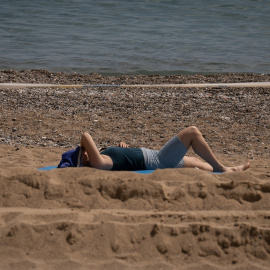 26/04/2023. Una mujer toma el sol en la playa de la Barceloneta, a 25 de abril de 2023, en Barcelona.