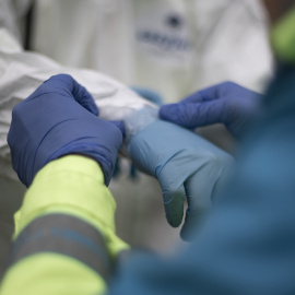 Un trabajador de una UVI móvil del SUMMA 112 se viste con el EPI durante una jornada de trabajo, en Madrid (España), a 29 de enero de 2021.