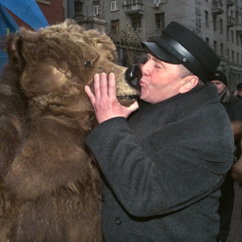 El líder del partido ultranacionalista ruso Liberal-Democrático Vladimir Zhirinovsky besa a un ruso vestido de oso durante una manifestación por el Día de la Constitución de Rusia en Moscú en 1999.- ALEXANDER NEMENOV / AFP