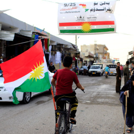 Un niño en bicicleta con la bandera del Kurdistán en una localidad de Irak. REUTERS/Thaier Al-Sudani