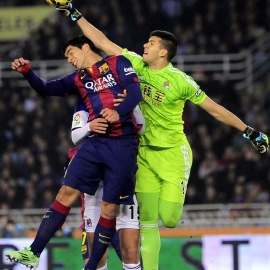 Gerónimo Rulli despeja un balón ante Luis Suárez en el partido de ida entre el Barcelona y la Real Sociedad en Anoeta.