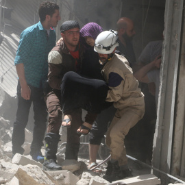 Varias personas sacan a heridos entre los escombros de un edificio derruido en Alepo por el lanzamiento de un misil. - REUTERS