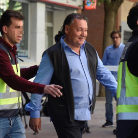 El presidente del Huesca, Agustín Lasaosa,d., junto a un policia a su salida de las oficinas del club tras ser detenido. /EFE