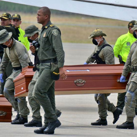 Personal de la Policía ayuda hoy, viernes 22 de junio de 2018, en Cali (Colombia), a cargar los ataúdes con los cuatro cuerpos hallados por las autoridades colombianas en una zona selvática. (ERNESTO GUZMÁN Jr. | EFE)