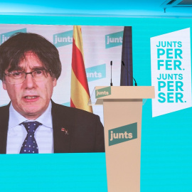 La número 2 de JxCat por Barcelona, Laura Borrás, observa al número 1 del partido por Barcelona, Carles Puigdemont (pantalla), durante una rueda de prensa para valorar los resultados obtenidos por su formación en los comicios catalanes dura