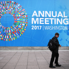 Un caminante pasea junto a la placa que anuncia la reunión anual del FMI. AFP/Jim Watson