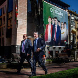 El lehendakari Iñigo Urkullu y el presidente del PNV, Andoni Ortuzar, caminan delante del cartel electoral de su formación. | EFE