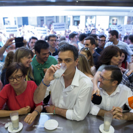 El secretario general del PSOE, Pedro Sánchez, en una heladería, con la protesta al fondo.  EFE/Jorge Zapata.