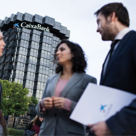 Tres empleados delante de un edificio de CaixaBank.
