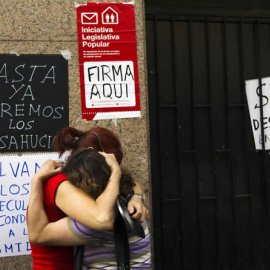 Dos mujeres se abrazan en la puerta de la casa de la que acaban de ser desahuciadas en Madrid, en 2012.- REUTERS/SUSANA VERA (ARCHIVO)