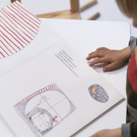 Un niño mirando un dibujo en un centro escolar.