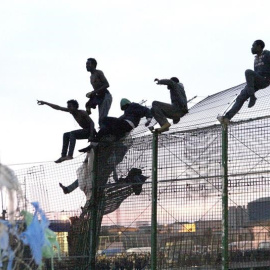 Un grupo de personas intentan saltar la frontera de Melilla. EFE