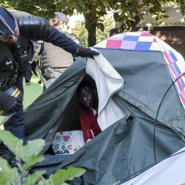 Un agente de policía durante el desalojo de cientos de personas migrantes acampadas en la ciudad de Nantes.- AFP/ SALON GOMIS