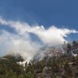 Medios aéreos siguen refrescando hoy el área del incendio forestal declarado ayer cercano a la localidad alicantina de Pego. EFE/NATXO FRANCÉS