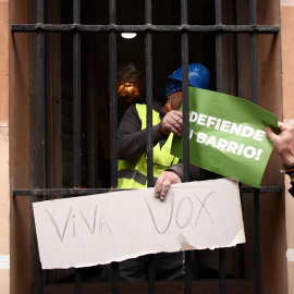 Un obrero recibe una pancarta de Vox en La Latina (Madrid), el 9 de abril de 2021.