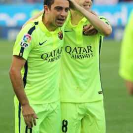 Xavi celebra junto a Iniesta el título de Liga en el Calderón. /AFP