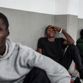 Varios migrantes descansando en una nave industrial del puerto de Barbate/Jairo Vargas