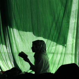 La silueta de una mujer leyendo un libro en Indonesia./REUTERS