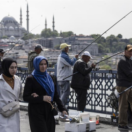 16/5/23 Varias personas en el puente de Galata, con la mezquita de Suleimán al fondo, ayer en Estambul.