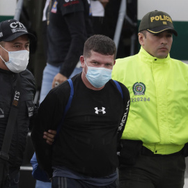 Francisco Luis Correa Galeano (c), capturado por el crimen del fiscal paraguayo Marcelo Pecci, es trasladado por agentes de la Policía y del Cuerpo Técnico de Investigación (CTI) en el Comando Aéreo de Transporte Militar (CATAM) hacia el Bu