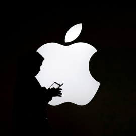 Una mujer mira el móvil enfrente de un logo de Apple en una tienda de la compañía situada en Shanghai, China. REUTERS/Aly Song/Archivo