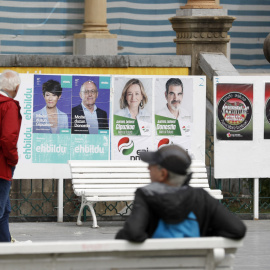 Unos ciudadanos observan varios carteles electorales este martes en San Sebastián, a 16 de mayo de 2023.