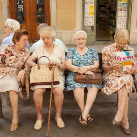 Cuatro mujeres mayores sentadas en un banco una plaza de Barcelona. AFP